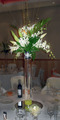 Lillies and Orchids in a tall vase.